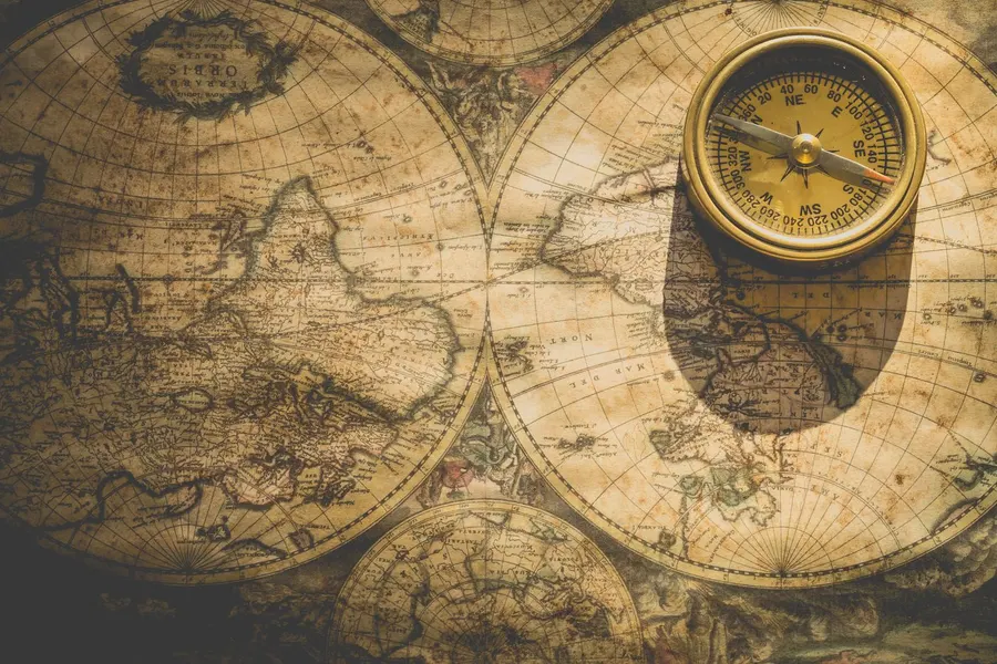 A compass resting on an antique world map